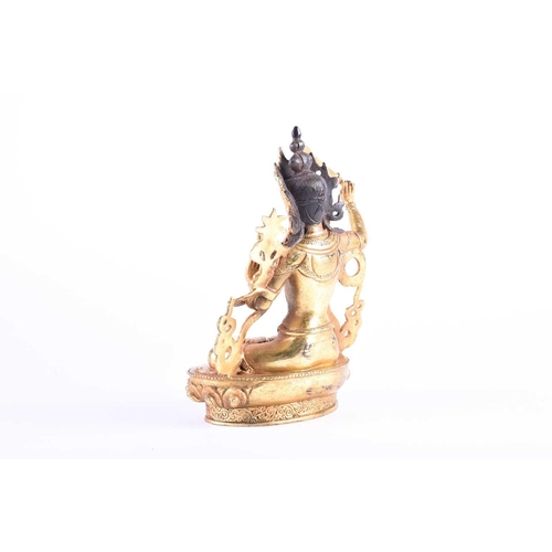 191 - A Sino Tibetan style gilt bronze figure of Manjushri, the left hand in Gyan mudra, on a lotus petal ... 