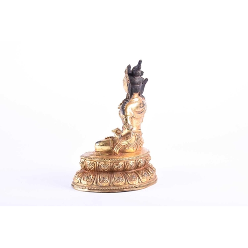 192 - A Sino Tibetan gilt bronze figure of Manjushri, decorated with cast jewels and robes, seated on a do... 