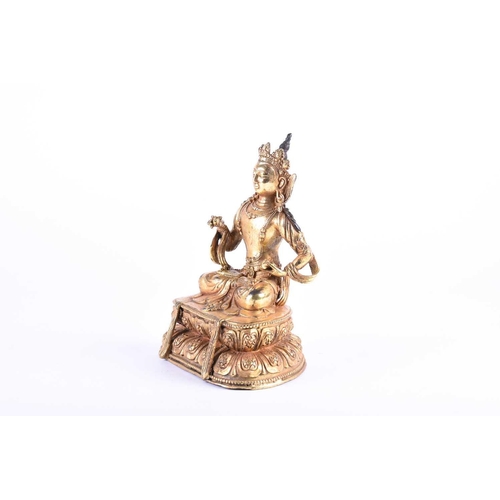 192 - A Sino Tibetan gilt bronze figure of Manjushri, decorated with cast jewels and robes, seated on a do... 