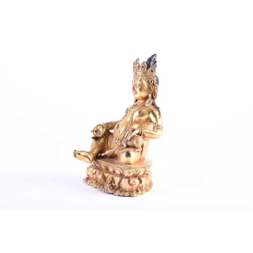 193 - A Sino Tibetan gilt bronze figure of Jambhala, seasted with his jewel spitting mongoose, on a throne... 