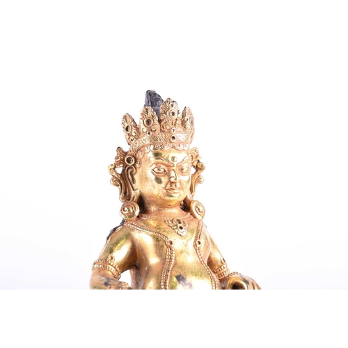 193 - A Sino Tibetan gilt bronze figure of Jambhala, seasted with his jewel spitting mongoose, on a throne... 