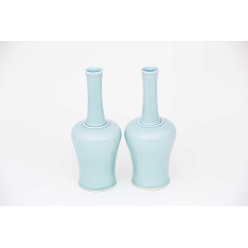 219 - A pair of Chinese celadon mallet shape vases, each with a slightly flared rim on a slender neck term... 