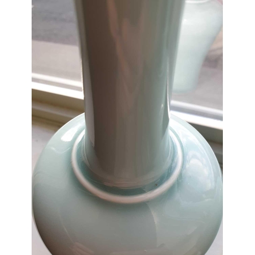 219 - A pair of Chinese celadon mallet shape vases, each with a slightly flared rim on a slender neck term... 