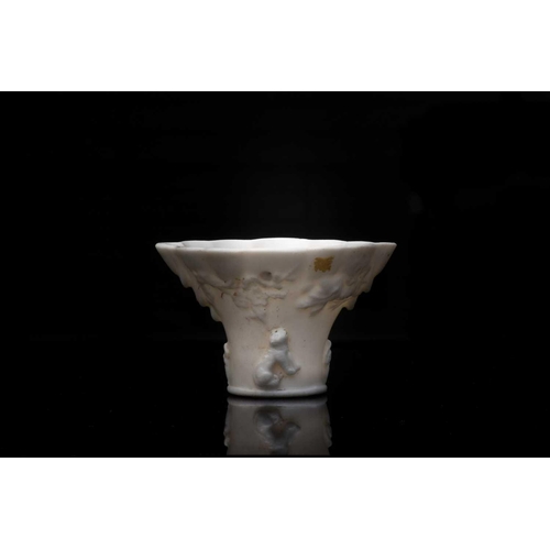 221 - A Chinese blanc de Chine cup, 18th century, modelled as a rhinoceros horn libation cup with scallope... 