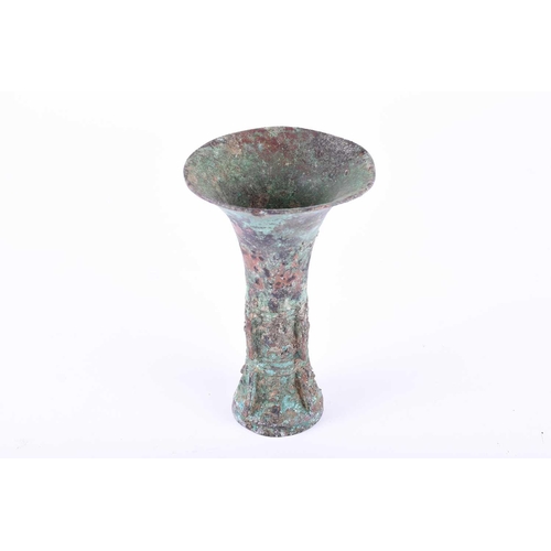 224 - A Chinese cast bronze Gu form ritual wine vessel, Shang Dynasty, with flaring rim above the tapering... 