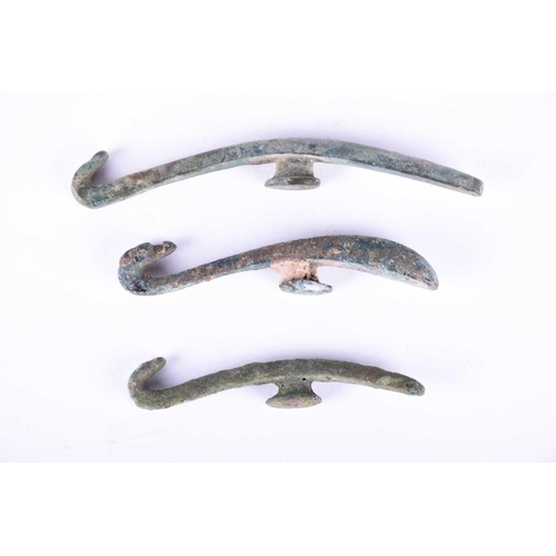 226 - Three Chinese bronze belt hooks, Warring States or later, each of typical elongated form, one with a... 