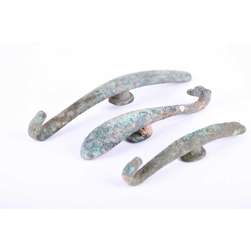 226 - Three Chinese bronze belt hooks, Warring States or later, each of typical elongated form, one with a... 