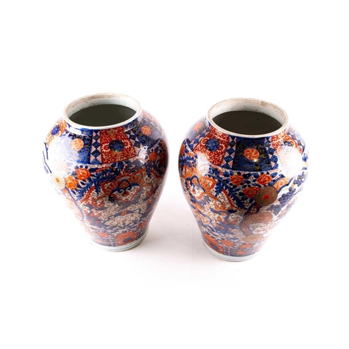 231 - A pair of large Arita imari vases and covers, mid 19th century, each baluster body densely decorated... 