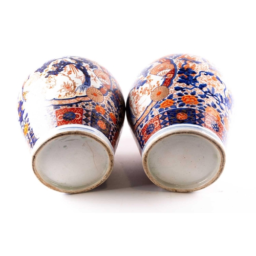 231 - A pair of large Arita imari vases and covers, mid 19th century, each baluster body densely decorated... 