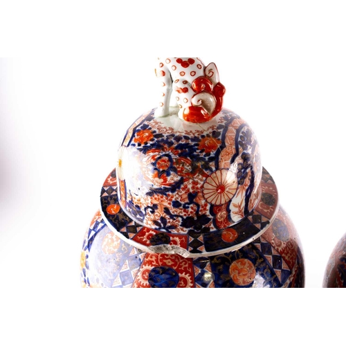 231 - A pair of large Arita imari vases and covers, mid 19th century, each baluster body densely decorated... 