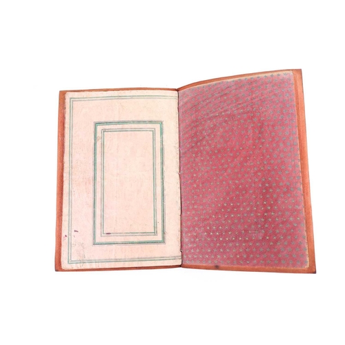 235 - A leather bound booklet of Persian script, each page with stylised foliate decoration heightened in ... 