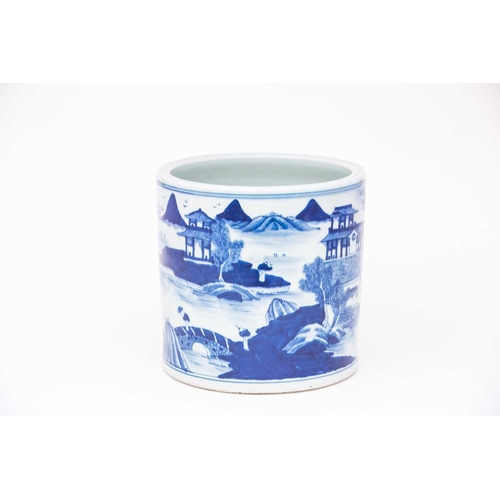 243 - A large Chinese blue & white brush pot, Bitong, painted throughout with a watery landscape of buildi... 