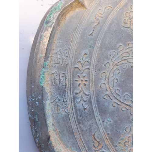 254 - A Chinese bronze mirror, Tang, 中国，铜镜一个，唐代 the six lobes enclosing relief tendrils and with three cha... 