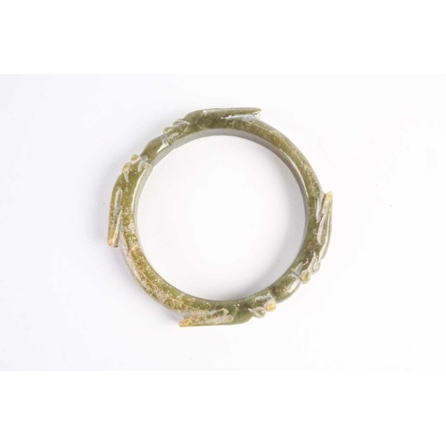 273 - A Chinese spinach green jade bangle, Warring States period, with four opposing dragons with long ear... 