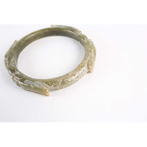 273 - A Chinese spinach green jade bangle, Warring States period, with four opposing dragons with long ear... 