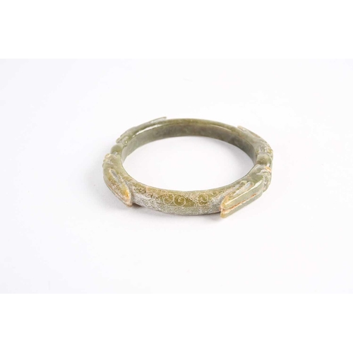 273 - A Chinese spinach green jade bangle, Warring States period, with four opposing dragons with long ear... 