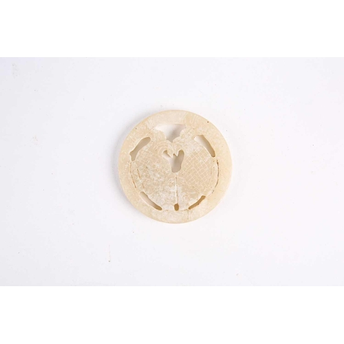 280 - A Chinese jade amulet, Warring States period, of circular form, the centre with two conjoined fish, ... 