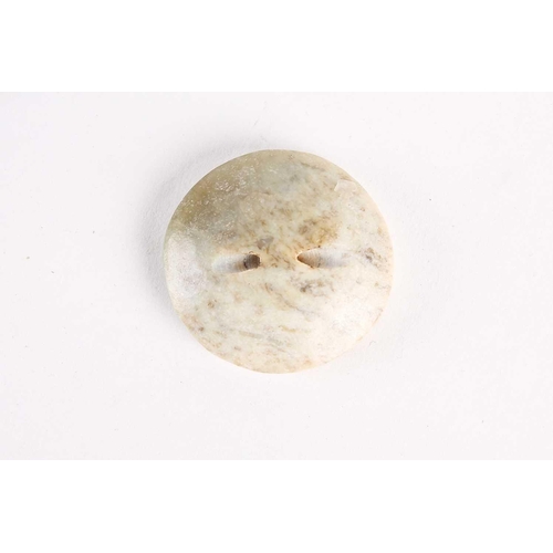 287 - A Chinese jade button/pommel, Han dynasty, of circular form, decorated with and archaic band enclosi... 