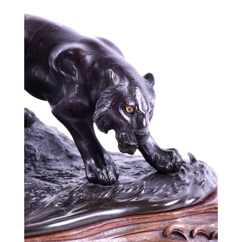 297 - A Japanese bronze group of two tigers, Meiji period, naturalistically modelled prowling by the side ... 