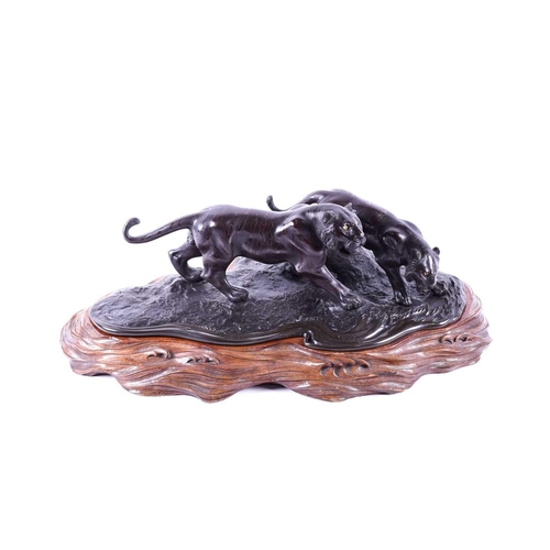 297 - A Japanese bronze group of two tigers, Meiji period, naturalistically modelled prowling by the side ... 