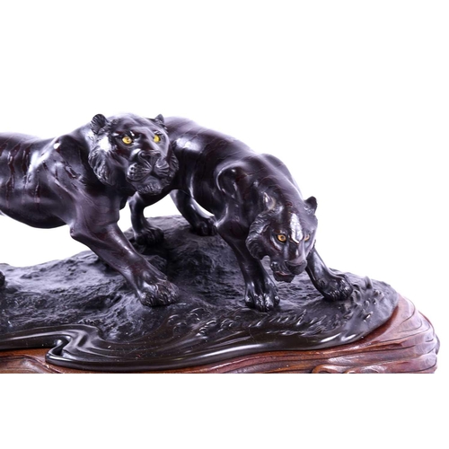 297 - A Japanese bronze group of two tigers, Meiji period, naturalistically modelled prowling by the side ... 