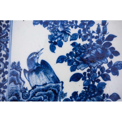 304 - A Chinese porcelain blue & white plaque, 19th century, painted with a bird upon a rocky outcrop eyei... 