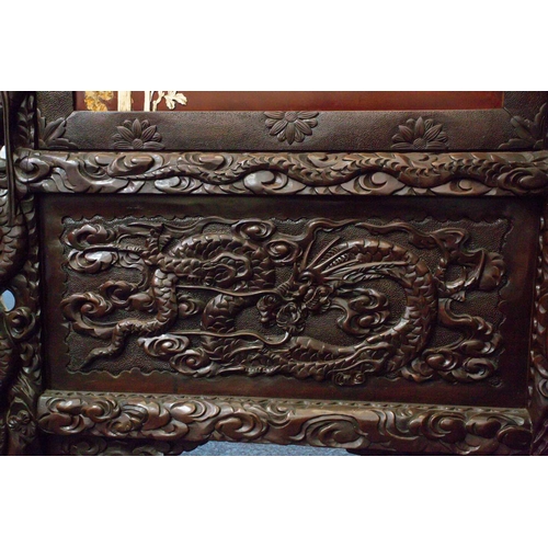 311 - A Japanese carved blackwood and ivory screen, Meiji period, circa 1880, the panels applied with high... 