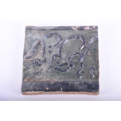 321 - A Persian Seljuk calligraphic tile, 11th/12th century, with relief moulded script picked out in blac... 