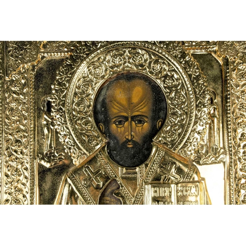 380 - A 19th century painted Russian icon on wood, with later overlaid gilt metal plaque, relief decorated... 