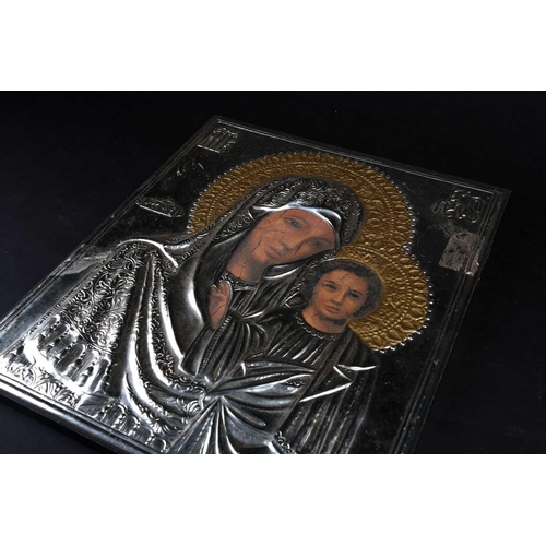 381 - A 20th century Russian icon, Mother & Child, with white metal overlay, finished with relief Cryillic... 