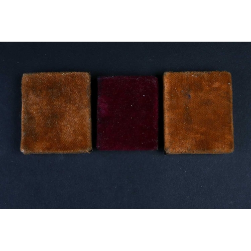 382 - A group of three 19th century miniature white metal-mounted Russian icons, each velvet backed, the l... 