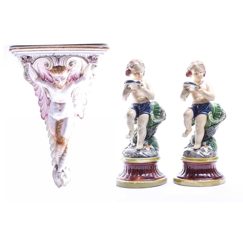 402 - An Italian tin glazed wall bracket, 19th century, modelled as a faun flanked by leafy scrolls beneat... 