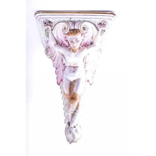 402 - An Italian tin glazed wall bracket, 19th century, modelled as a faun flanked by leafy scrolls beneat... 