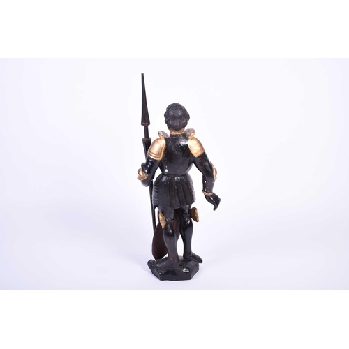 446 - An 18th century carved softwood figure of St George, painted black and gilt on gesso, standing with ... 