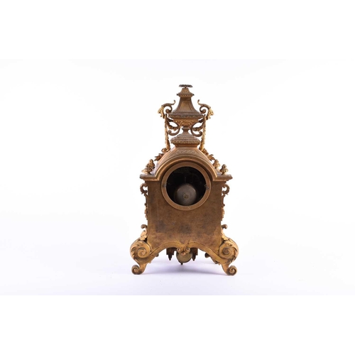 528 - A 19th century French ormolu mantel clock, surmounted by a vase with bellflower swags and lion masks... 