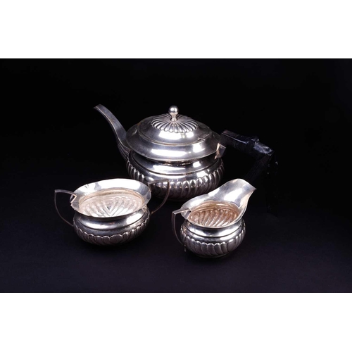 551 - A three piece white metal teaset, comprising teapot, creamer and sucrier, the tepaot marked 'Silver'... 