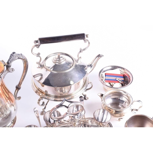 577 - A collection of silver plated items, to include a cocktail shaker, spirit kettle on stand, egg set o... 