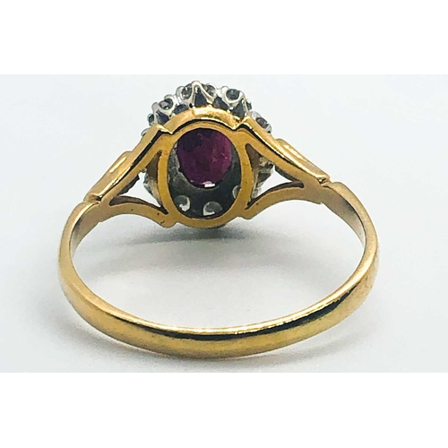 581A - An 18ct yellow gold, diamond, and ruby cluster ring, set with a mixed oval-cut ruby, within a border... 