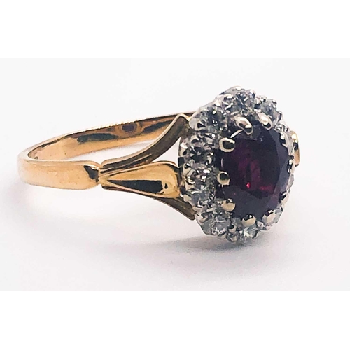 581A - An 18ct yellow gold, diamond, and ruby cluster ring, set with a mixed oval-cut ruby, within a border... 