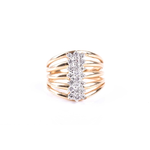 581 - A yellow metal and diamond dress ring, the five-bar split shank centred with a triple row of round b... 