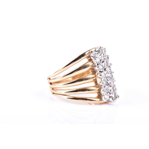 581 - A yellow metal and diamond dress ring, the five-bar split shank centred with a triple row of round b... 