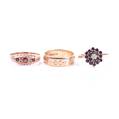 586 - A 9ct gold engraved wedding band; a three stone half hoop garnet ring in 9ct rose gold mount, and a ... 