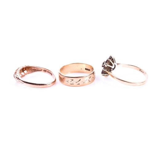 586 - A 9ct gold engraved wedding band; a three stone half hoop garnet ring in 9ct rose gold mount, and a ... 