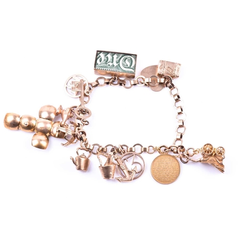 601 - A 9ct yellow gold charm bracelet, suspended with various charms including a pram, a Paris charm, a d... 