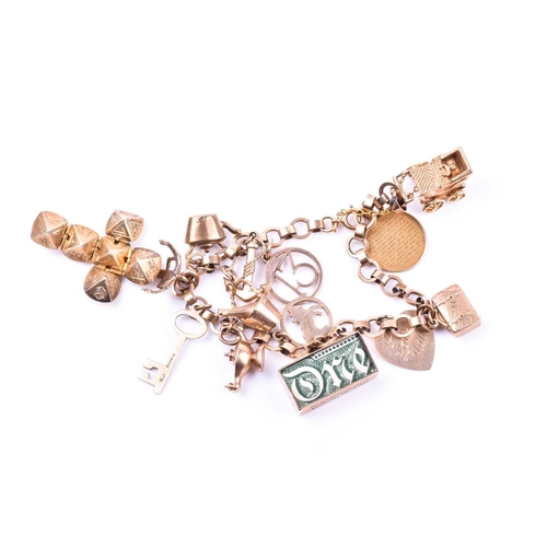 601 - A 9ct yellow gold charm bracelet, suspended with various charms including a pram, a Paris charm, a d... 