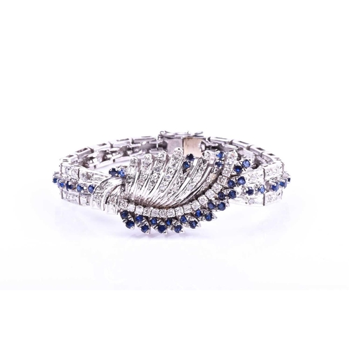 605 - A white metal, diamond, and sapphire bracelet, the swept central segment set with round brilliant-cu... 