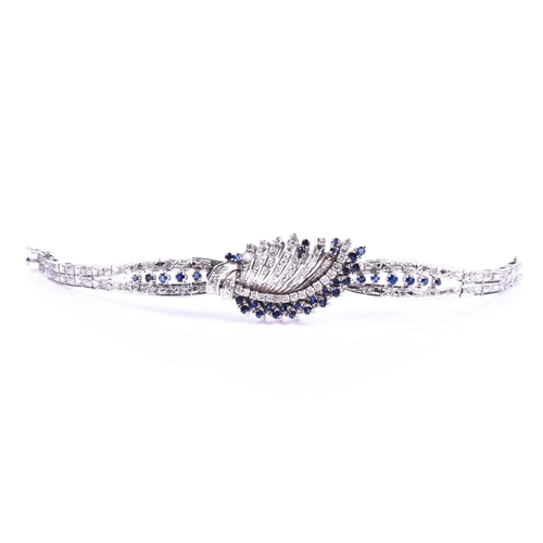 605 - A white metal, diamond, and sapphire bracelet, the swept central segment set with round brilliant-cu... 