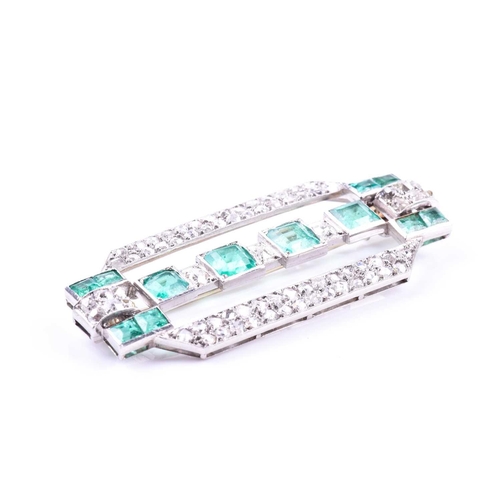 607 - An Art Deco diamond and emerald brooch the rectangular mount inset with twelve emeralds (likely of C... 