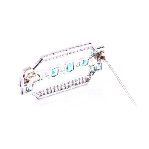 607 - An Art Deco diamond and emerald brooch the rectangular mount inset with twelve emeralds (likely of C... 