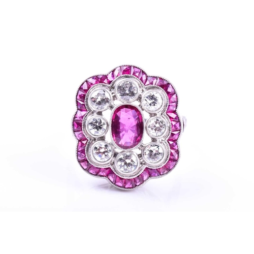 616 - An unusual platinum, diamond, and ruby cocktail ring, centred with a mixed oval-cut ruby, within a b... 